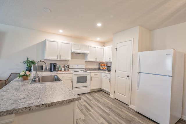 1937 SW Aguero St, Port Saint Lucie, FL 34953 - kitchen with white appliances, under cabinet range hood, light wood-style flooring, white cabinets, and recessed lighting