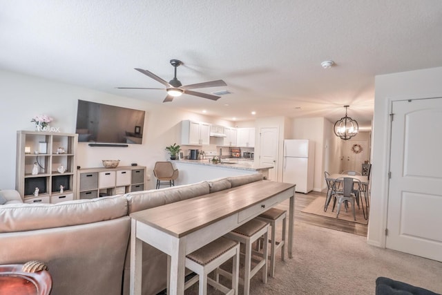 1937 SW Aguero St, Port Saint Lucie, FL 34953 - living room featuring a chandelier, a ceiling fan, recessed lighting, and light carpet