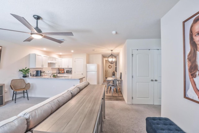 1937 SW Aguero St, Port Saint Lucie, FL 34953 - living room with light colored carpet, ceiling fan, a chandelier, and recessed lighting