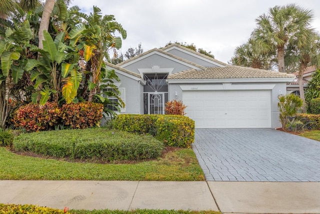 10856 Royal Caribbean Cir, Boynton Beach, FL 33437 - view of front of house featuring a garage, decorative driveway, and stucco siding