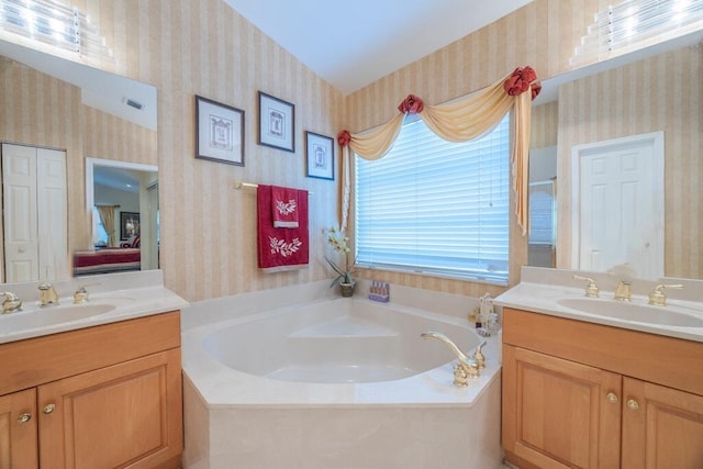 10856 Royal Caribbean Cir, Boynton Beach, FL 33437 - full bathroom with wallpapered walls, two vanities, and a garden tub