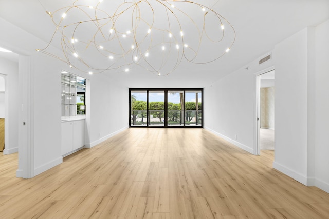 3440 S Ocean Blvd Unit 107S, Palm Beach, FL 33480 - unfurnished living room with a chandelier and light wood finished floors