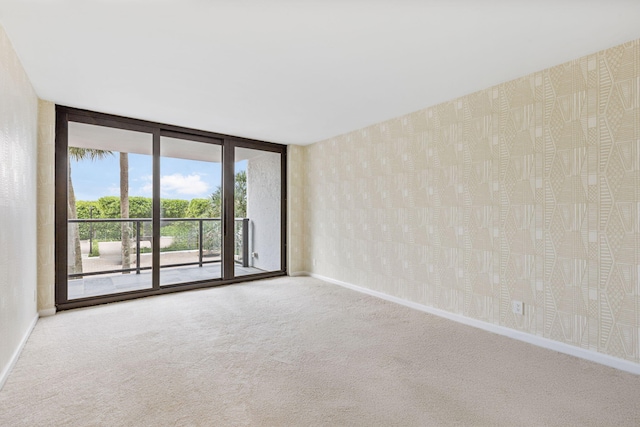3440 S Ocean Blvd Unit 107S, Palm Beach, FL 33480 - empty room with carpet floors, a wall of windows, and wallpapered walls