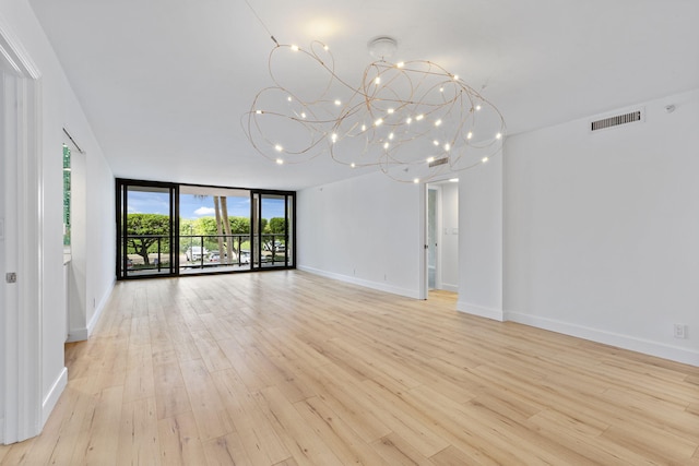 3440 S Ocean Blvd Unit 107S, Palm Beach, FL 33480 - unfurnished room with light wood-style flooring, a chandelier, and a wall of windows