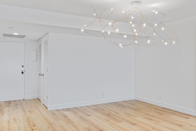 3440 S Ocean Blvd Unit 107S, Palm Beach, FL 33480 - spare room with wood finished floors and a chandelier