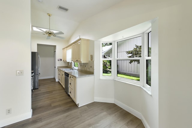 13116 SE Point O Woods Ct, Hobe Sound, FL 33455 - kitchen featuring appliances with stainless steel finishes, light countertops, light wood-style flooring, vaulted ceiling, and backsplash