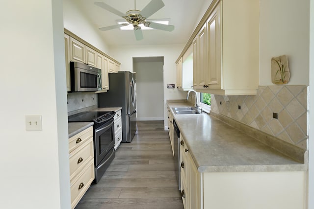 13116 SE Point O Woods Ct, Hobe Sound, FL 33455 - kitchen with appliances with stainless steel finishes, a ceiling fan, light wood finished floors, cream cabinetry, and backsplash