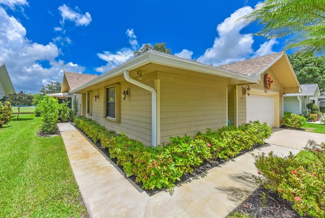13116 SE Point O Woods Ct, Hobe Sound, FL 33455 - view of property exterior featuring a yard, roof with shingles, concrete driveway, and a garage