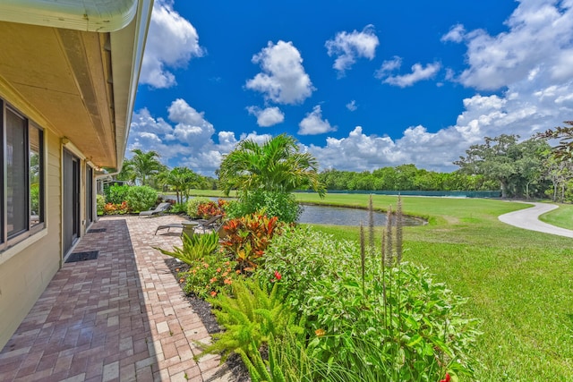 13116 SE Point O Woods Ct, Hobe Sound, FL 33455 - view of green lawn with a water view and a patio area