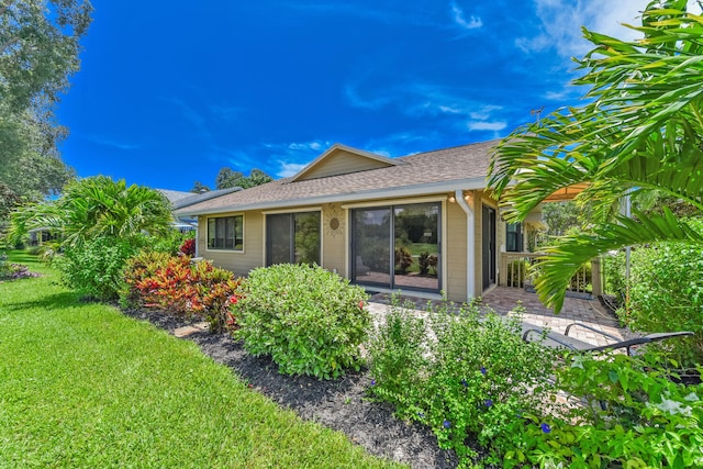 13116 SE Point O Woods Ct, Hobe Sound, FL 33455 - rear view of property featuring a shingled roof and a lawn