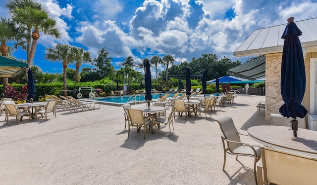 13116 SE Point O Woods Ct, Hobe Sound, FL 33455 - community pool featuring outdoor dining area and a patio