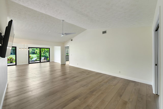13116 SE Point O Woods Ct, Hobe Sound, FL 33455 - unfurnished living room with a textured ceiling, a ceiling fan, wood finished floors, and lofted ceiling