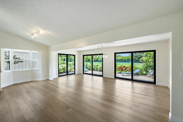 13116 SE Point O Woods Ct, Hobe Sound, FL 33455 - unfurnished room featuring wood finished floors, rail lighting, and vaulted ceiling