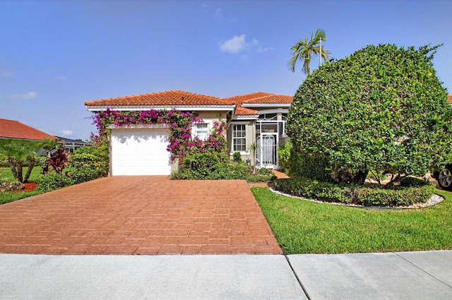 10853 Royal Caribbean Cir, Boynton Beach, FL 33437 - view of front facade featuring a garage, decorative driveway, a tiled roof, and stucco siding