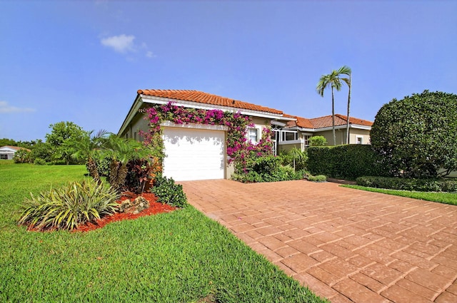 10853 Royal Caribbean Cir, Boynton Beach, FL 33437 - mediterranean / spanish house featuring a garage, decorative driveway, a tiled roof, a front yard, and stucco siding