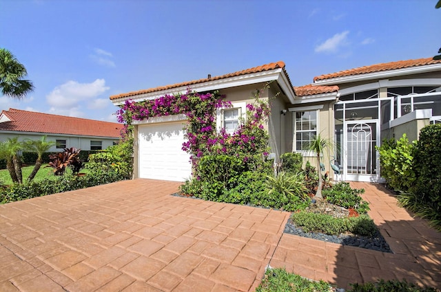 10853 Royal Caribbean Cir, Boynton Beach, FL 33437 - view of front of property with a tiled roof, an attached garage, stucco siding, and decorative driveway