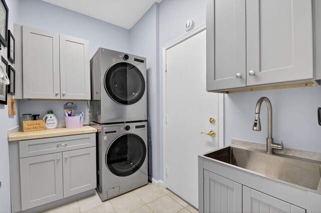 10853 Royal Caribbean Cir, Boynton Beach, FL 33437 - washroom featuring stacked washer and clothes dryer, cabinet space, and light tile patterned floors