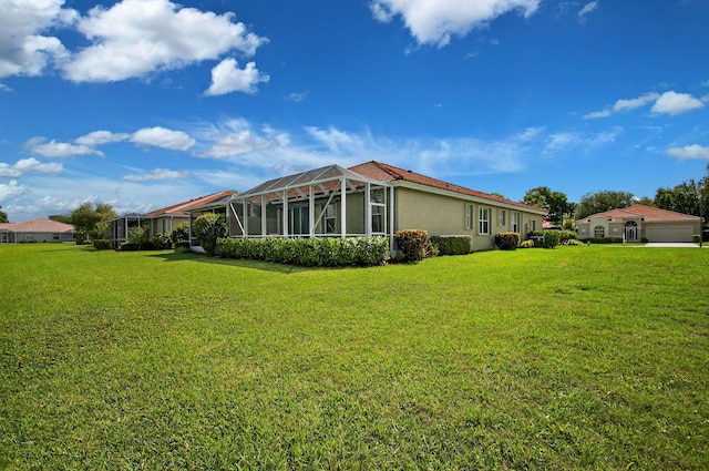 10853 Royal Caribbean Cir, Boynton Beach, FL 33437 - rear view of property featuring a lawn, stucco siding, and glass enclosure