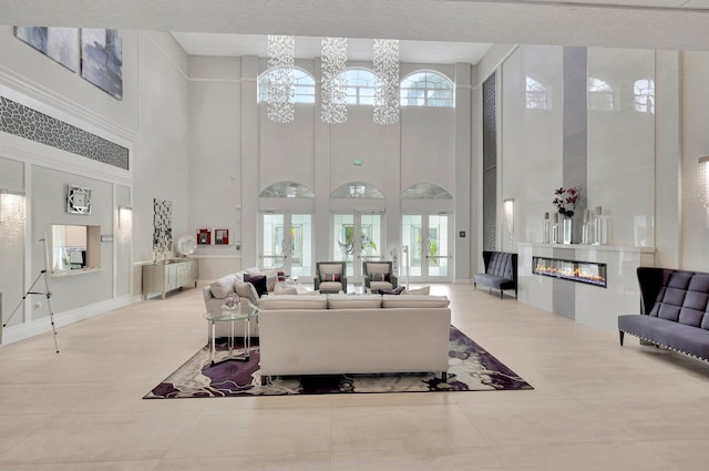 10853 Royal Caribbean Cir, Boynton Beach, FL 33437 - tiled living room with a high ceiling, a glass covered fireplace, and plenty of natural light
