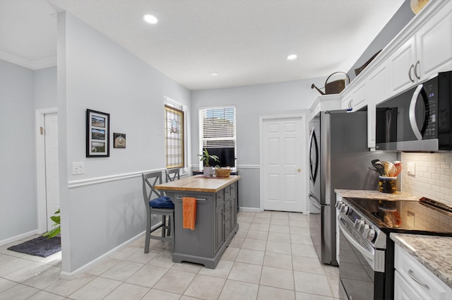 10853 Royal Caribbean Cir, Boynton Beach, FL 33437 - kitchen with appliances with stainless steel finishes, white cabinetry, butcher block countertops, tasteful backsplash, and recessed lighting