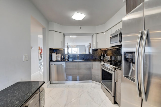 7260 Kinghurst Dr Unit 401, Delray Beach, FL 33446 - kitchen featuring stainless steel appliances, a chandelier, light marble finish flooring, backsplash, and white cabinetry