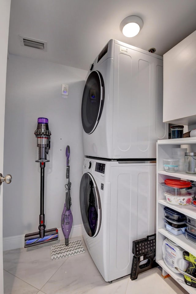 7260 Kinghurst Dr Unit 401, Delray Beach, FL 33446 - laundry area with stacked washer / drying machine and tile patterned floors