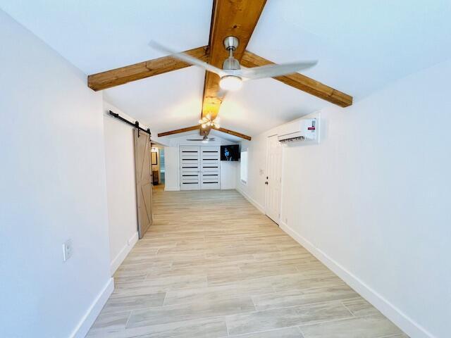 181 NE 15th Ter, Boca Raton, FL 33432 - hall featuring a barn door, a wall unit AC, and light wood-style flooring