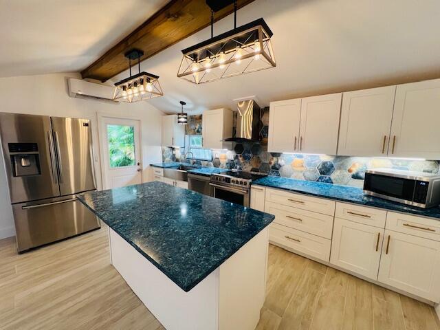 181 NE 15th Ter, Boca Raton, FL 33432 - kitchen with appliances with stainless steel finishes, wall chimney exhaust hood, tasteful backsplash, light wood finished floors, and white cabinetry