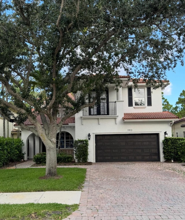 1913 Flower Dr, Palm Beach Gardens, FL 33410 - mediterranean / spanish house with a tile roof, a balcony, an attached garage, decorative driveway, and stucco siding