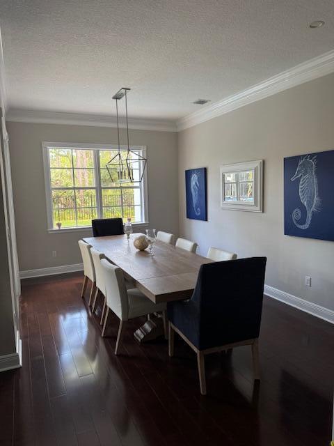 1913 Flower Dr, Palm Beach Gardens, FL 33410 - dining area featuring crown molding, dark wood-type flooring, a chandelier, and a textured ceiling