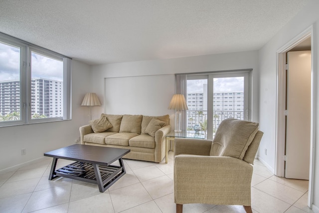 3221 S Ocean Blvd Unit 501, Highland Beach, FL 33487 - living room featuring plenty of natural light, a textured ceiling, and light tile patterned floors