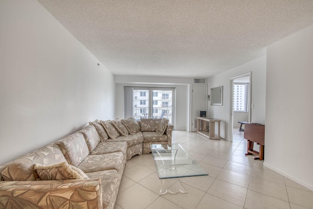 3221 S Ocean Blvd Unit 501, Highland Beach, FL 33487 - living room featuring a textured ceiling and light tile patterned flooring