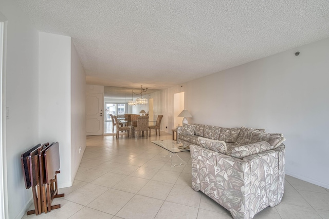 3221 S Ocean Blvd Unit 501, Highland Beach, FL 33487 - living area with a textured ceiling, a chandelier, and light tile patterned floors