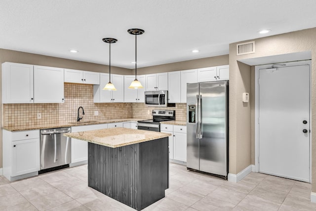 5610 Coach House Cir Unit C, Boca Raton, FL 33486 - kitchen with appliances with stainless steel finishes, white cabinetry, backsplash, hanging light fixtures, and a kitchen island