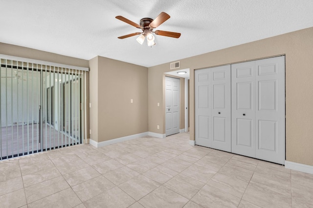 5610 Coach House Cir Unit C, Boca Raton, FL 33486 - unfurnished bedroom featuring a textured ceiling, light tile patterned floors, a closet, and a ceiling fan