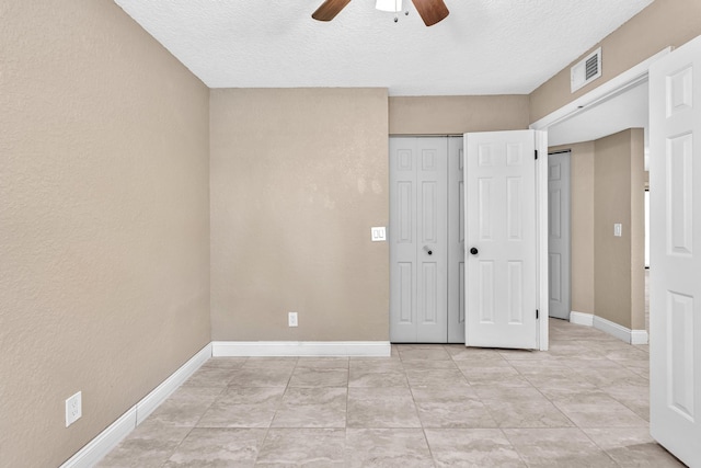 5610 Coach House Cir Unit C, Boca Raton, FL 33486 - unfurnished bedroom featuring a textured ceiling, a closet, light tile patterned floors, and a ceiling fan