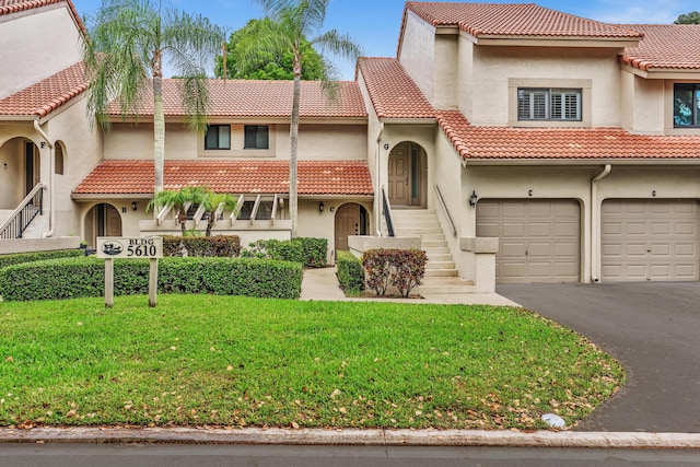 5610 Coach House Cir Unit C, Boca Raton, FL 33486 - mediterranean / spanish-style house with a tiled roof, stucco siding, a front yard, driveway, and an attached garage