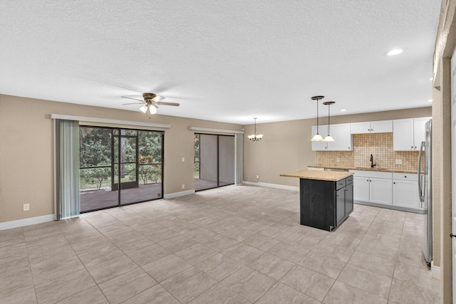 5610 Coach House Cir Unit C, Boca Raton, FL 33486 - kitchen featuring a center island, ceiling fan, decorative backsplash, open floor plan, and white cabinets