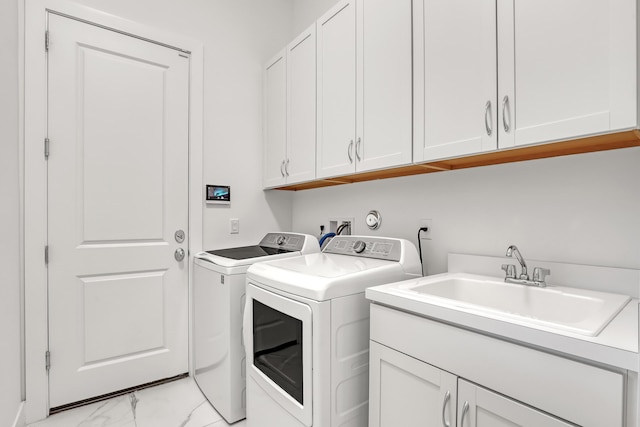 13501 Artisan Cir, Palm Beach Gardens, FL 33418 - laundry room featuring independent washer and dryer, light marble finish flooring, and cabinet space