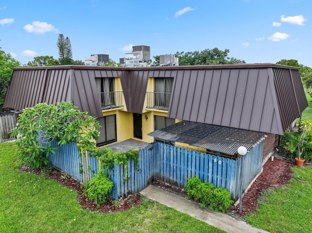 3665 Silver Lace Ln Unit 80, Boynton Beach, FL 33436 - rear view of house with a balcony and a yard