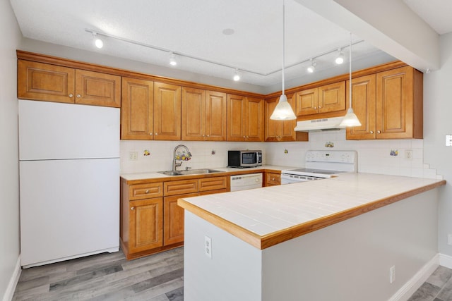 3665 Silver Lace Ln Unit 80, Boynton Beach, FL 33436 - kitchen featuring white appliances, under cabinet range hood, brown cabinetry, and light wood-style floors