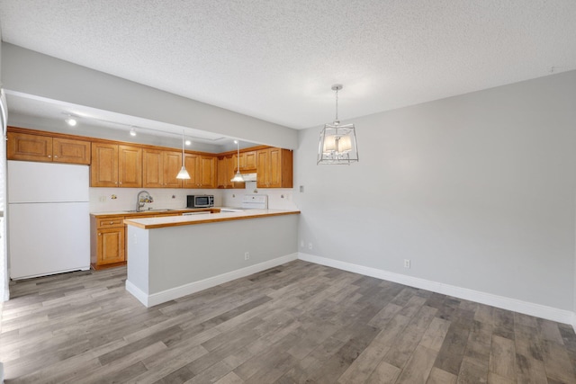 3665 Silver Lace Ln Unit 80, Boynton Beach, FL 33436 - kitchen featuring freestanding refrigerator, stainless steel microwave, range, wood finished floors, and a textured ceiling