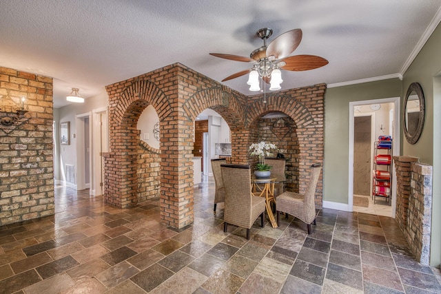 130 S Ocean Breeze, Lake Worth Beach, FL 33460 - dining area with stone tile floors, ceiling fan, arched walkways, a textured ceiling, and brick wall