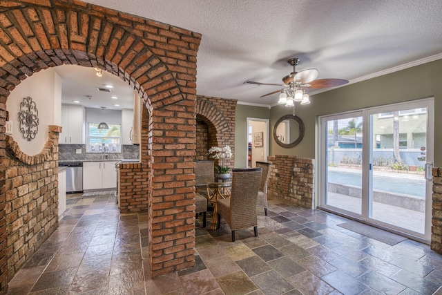 130 S Ocean Breeze, Lake Worth Beach, FL 33460 - dining room featuring stone tile flooring, healthy amount of natural light, ceiling fan, a textured ceiling, and ornamental molding