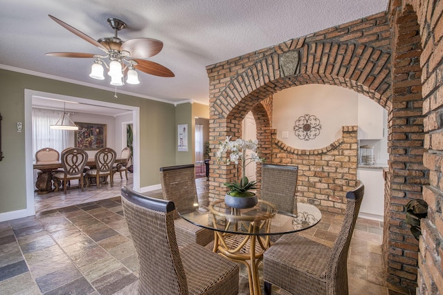 130 S Ocean Breeze, Lake Worth Beach, FL 33460 - dining room with stone tile flooring, ceiling fan, a textured ceiling, crown molding, and arched walkways