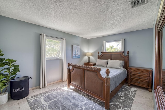 130 S Ocean Breeze, Lake Worth Beach, FL 33460 - bedroom with multiple windows, light tile patterned floors, and a textured ceiling