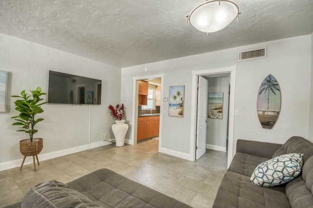 130 S Ocean Breeze, Lake Worth Beach, FL 33460 - living room featuring a textured ceiling and light tile patterned floors