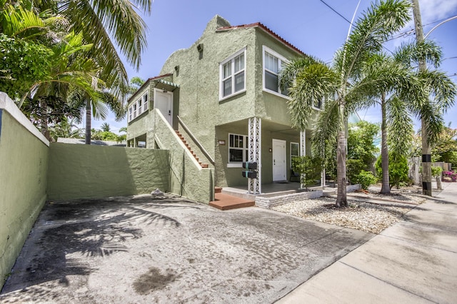 130 S Ocean Breeze, Lake Worth Beach, FL 33460 - view of side of home featuring stucco siding, a porch, and a tile roof