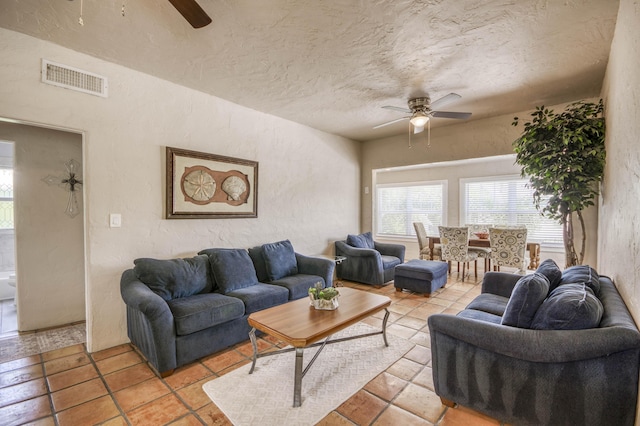 130 S Ocean Breeze, Lake Worth Beach, FL 33460 - living area featuring ceiling fan, plenty of natural light, a textured wall, a textured ceiling, and light tile patterned floors