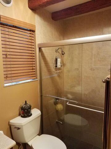 1016 N E St, Lake Worth Beach, FL 33460 - bathroom featuring a shower stall and beamed ceiling